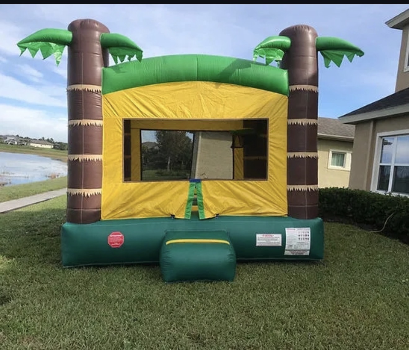 Palm tree themed bounce house set up on a sunny day